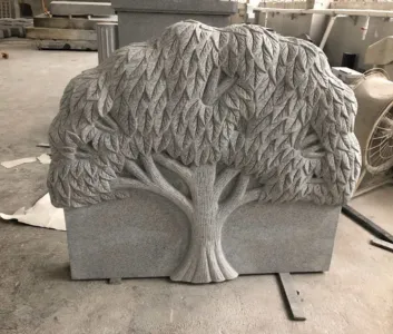 Tree-of-life sculpted in relief across a granite tablet